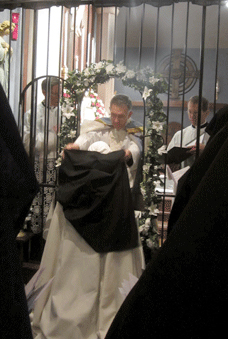 The Priest places the veil on the newly professed