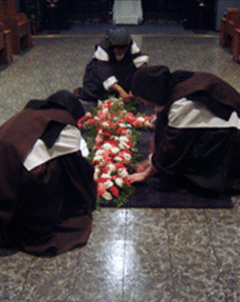 Sisters work together to assemble the cross of flowers early in the morning.