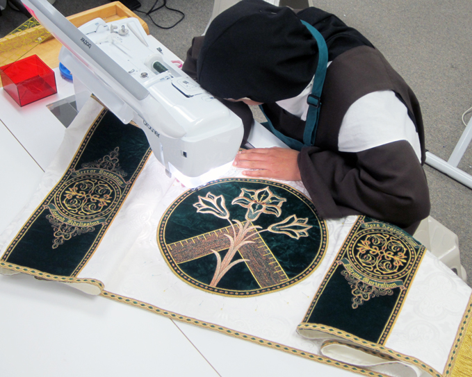 Sister sews applique onto the humeral veil